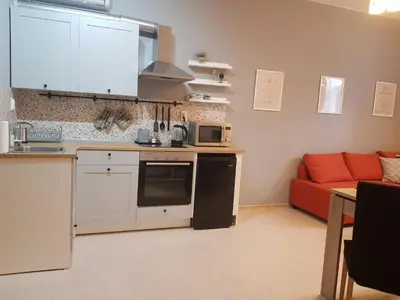 a kitchen with a red couch in a living room at Radomir Downtown Apartments in Radomir