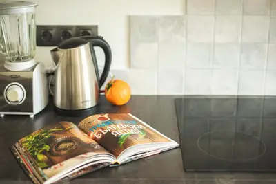 a book on a counter with an orange and a blender at Sunny studio on ulica Lyuben Karavelov in Sofia