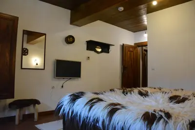 a bedroom with a bed with a large animal blanket at Къща за гости Гайтана in Shiroka Lŭka