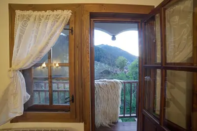 a door to a balcony with a view of a mountain at Къща за гости Гайтана in Shiroka Lŭka