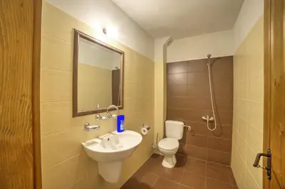 a bathroom with a sink and a toilet and a mirror at Къща за гости Гайтана in Shiroka Lŭka