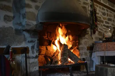 a brick oven with a fire in it at Къща за гости Гайтана in Shiroka Lŭka