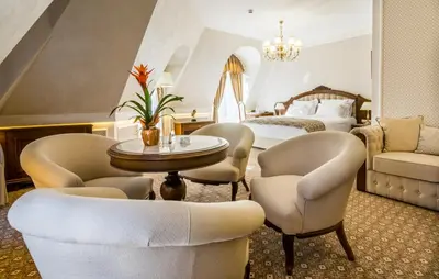 a hotel room with a bed and chairs and a table at Residence City Garden - Certificate of Excellence Top 10 BEST Five-Stars City Hotels for 2024 awarded by HTIF in Plovdiv