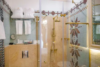 a bathroom with a shower with a glass door at Residence City Garden - Certificate of Excellence Top 10 BEST Five-Stars City Hotels for 2024 awarded by HTIF in Plovdiv