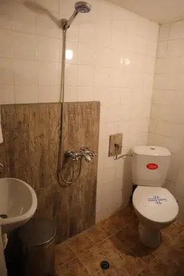 a bathroom with a toilet and a sink and a shower at Roots Apartment in Borovets