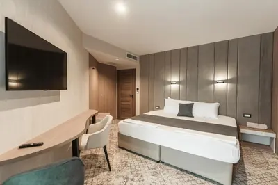 a hotel room with a bed and a desk and a television at Medite Spa Resort and Villas in Sandanski