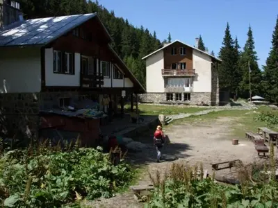 a woman is standing in front of a house at хижа 