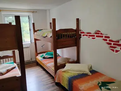 a room with three bunk beds and a window at хижа 