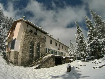 a building in the snow with snow covered trees at хижа 