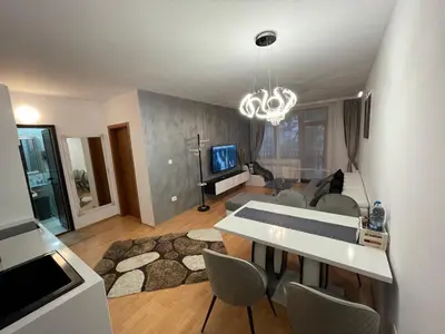 a living room with a couch and a table and chairs at Borovets Mountain Apartment Sequoia in Borovets