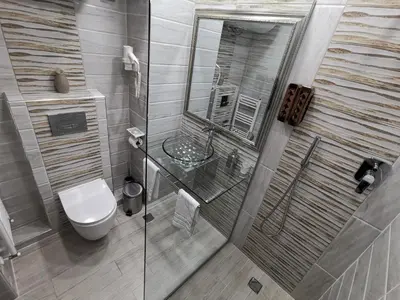 a bathroom with a toilet and a glass shower at Borovets Mountain Apartment Sequoia in Borovets