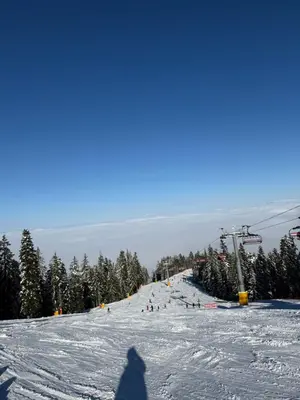 a shadow of a person standing on a snow covered ski slope at Borovets Mountain Apartment Sequoia in Borovets