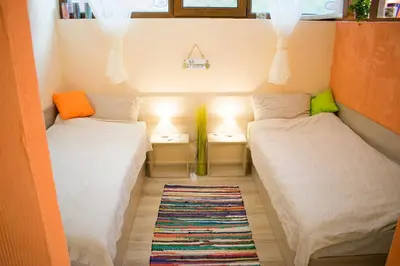 two beds in a small room with lamps and a rug at 4 Seasons apartments, A1 in Plovdiv