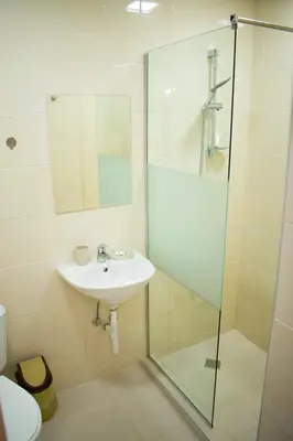 a bathroom with a sink and a glass shower at 4 Seasons apartments, A1 in Plovdiv