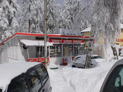 a snow covered building with cars parked in front of it at Borovets Apartment, Villa Park in Borovets