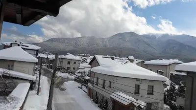 a town covered in snow with mountains in the background at Bella Vista Guesthouse in Bansko