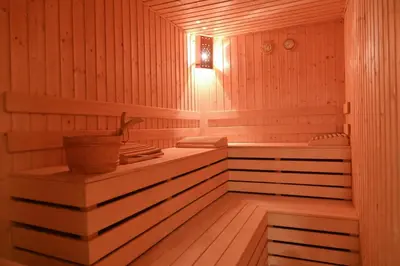 a wooden sauna with a tub and a sink at Bella Vista Guesthouse in Bansko