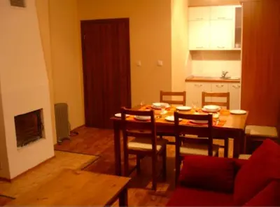 a dining room with a table and chairs and a kitchen at MD Alexander Services Apartments in Bansko