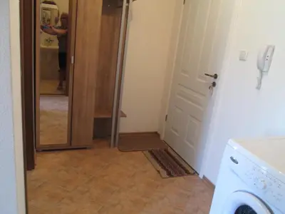 a laundry room with a door and a person taking a picture at MD Alexander Services Apartments in Bansko