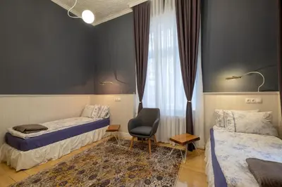 a room with two beds and a chair and a window at Temptation in Sofia - 24h Self Check-in in Sofia