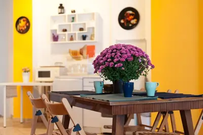 a dining room table with purple flowers on it at Vitosha Blvd - Family and Friends Apart in Sofia