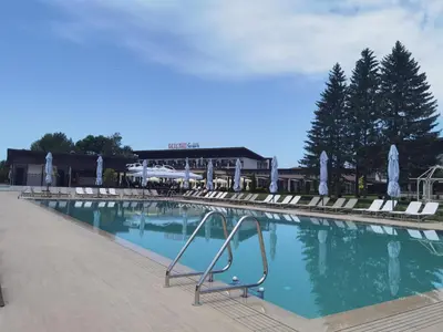 a large swimming pool with chairs and a building at Belchin Garden SPA&Wellness in Belchin