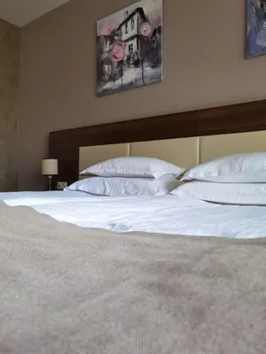 a bed with white sheets and pillows in a bedroom at Belchin Garden SPA&Wellness in Belchin