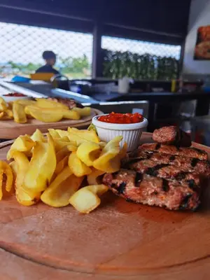 a plate of food with meat and chips on a table at Belchin Garden SPA&Wellness in Belchin