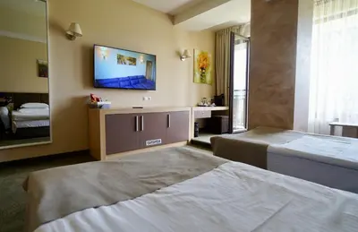 a hotel room with two beds and a tv on the wall at Belchin Garden SPA&Wellness in Belchin