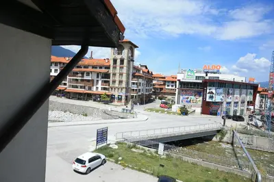 a white van driving down a street in a city at Great location near lift in Bansko
