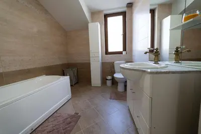 a bathroom with a tub and a sink and a toilet at Ikonomov House in Bansko
