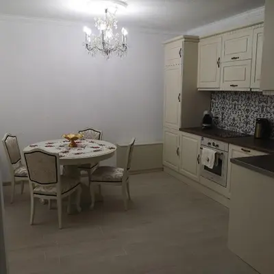 a kitchen with a table and chairs and a chandelier at Ikonomov House in Bansko