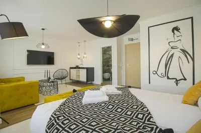 a bedroom with a large bed with a dress on the wall at Boutique Apartments Blagoevgrad in Blagoevgrad