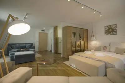 a bedroom with a large bed and a living room at Boutique Apartments Blagoevgrad in Blagoevgrad