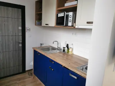 a kitchen with blue cabinets and a sink at Studio Oslo byPMM in Plovdiv