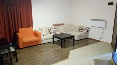 a living room with a couch and an orange chair at Villa Bojinovi - Forest Nook 2 in Pamporovo