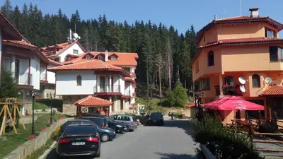 a group of cars parked on a street next to buildings at Villa Bojinovi - Forest Nook 2 in Pamporovo