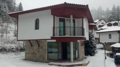 a house with a balcony in the snow at Villa Bojinovi - Forest Nook 2 in Pamporovo