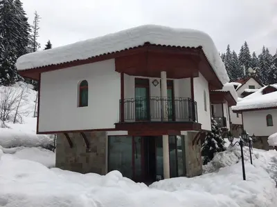 a snow covered house with a balcony in the snow at Villa Bojinovi - Forest Nook 2 in Pamporovo