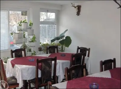 a dining room with a table and chairs and a bird on the wall at Family Hotel Velevi in Velingrad