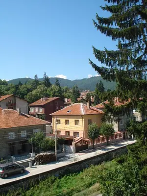 a town with houses and a car on a street at Family Hotel Velevi in Velingrad