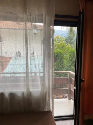 a bedroom with a window with a view of a balcony at Iglika Bansko in Bansko