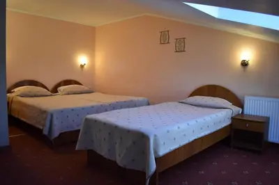 two beds in a hotel room with two bedsvisor at Family Hotel Bashtina Kashta in Koprivshtitsa