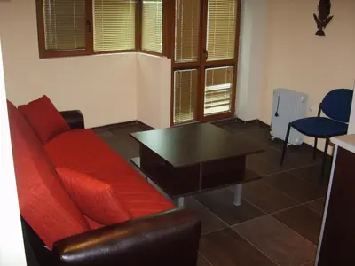 a living room with a red couch and a table at Hotel Trakart Residence in Plovdiv