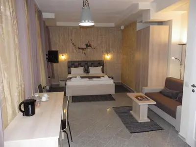 a bedroom with a bed and a couch and a table at Mini Sofia in Sofia