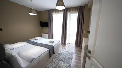 a bedroom with a white bed and a large window at Mini Sofia in Sofia