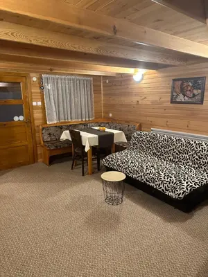 a living room with a couch and a table at Еднофамилна дървена къщичка in Beli Iskar