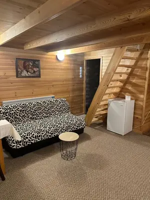 a attic room with two beds and a staircase at Еднофамилна дървена къщичка in Beli Iskar