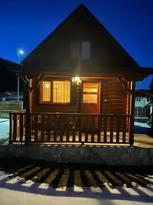 a log cabin in the snow at night at Еднофамилна дървена къщичка in Beli Iskar