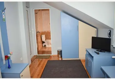 a room with a blue desk and a bathroom at Family Hotel Miglena in Govedartsi